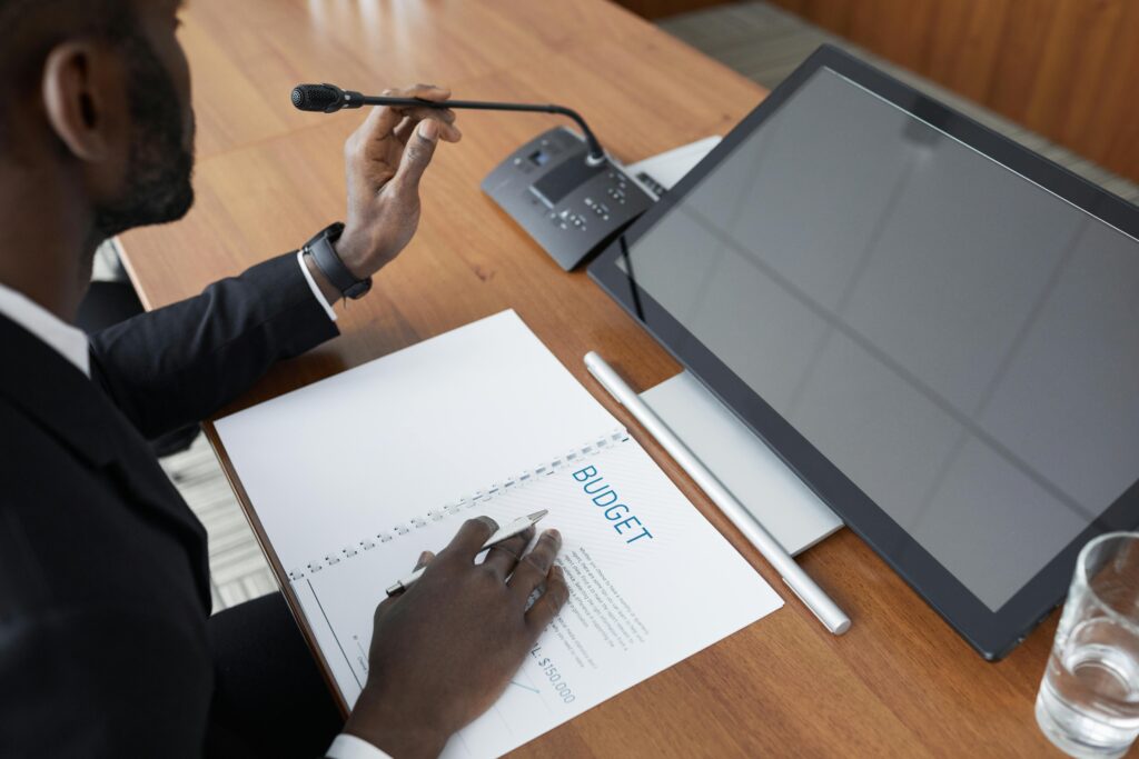 A business person presents a budget using a microphone after learning how to choose audio visual solutions for business